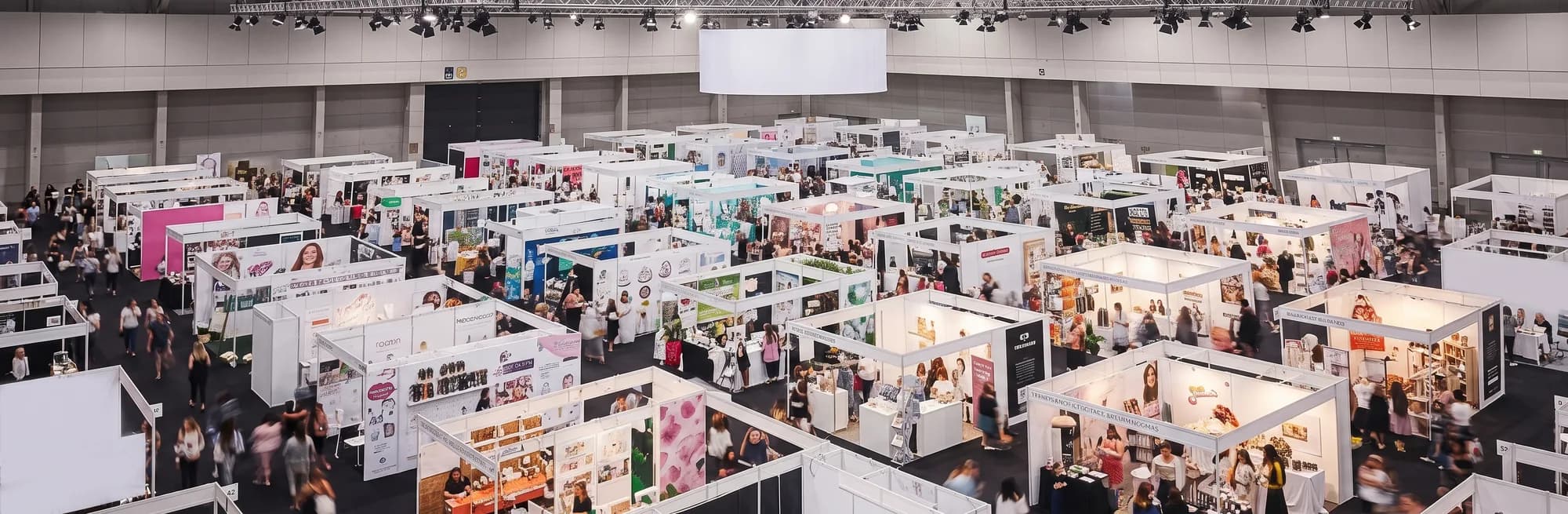 Aerial view of a bright trade fair floor, booths and crowds in a convention hall